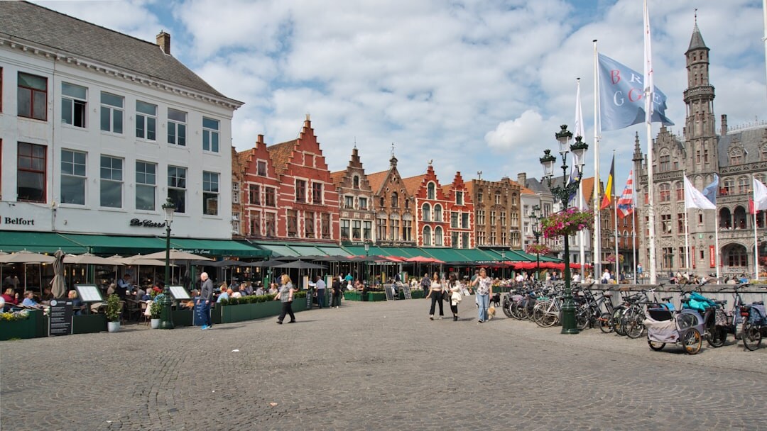 European shopping street in a Belgian city lined with storefronts and pedestrians
